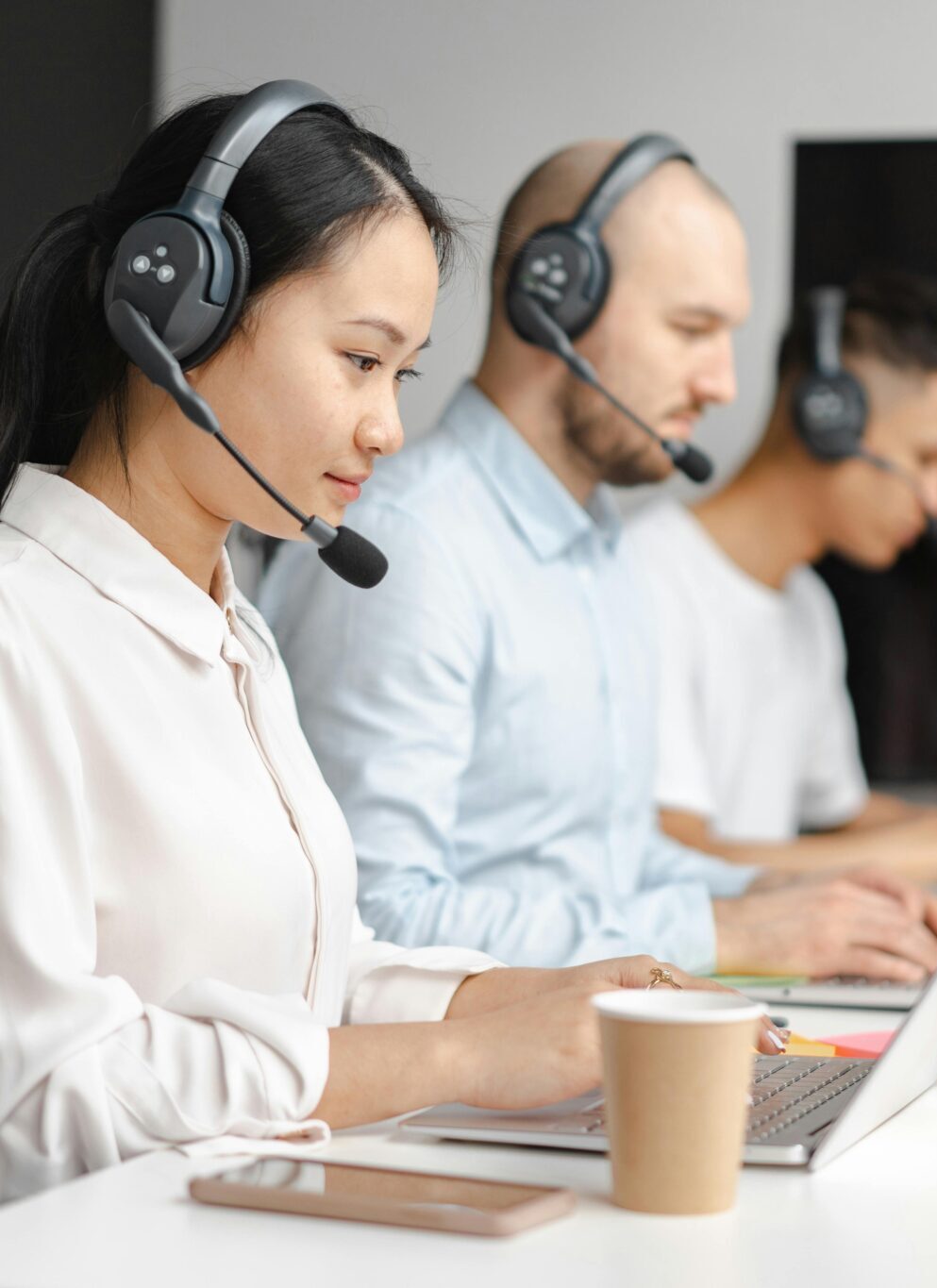 image of a call center with three people waiting to pick up the line